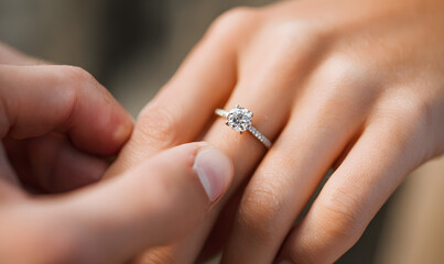 Man putting on girl finger engagement ring