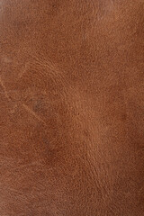 A close-up, full-frame shot of a rich brown distressed leather surface, showcasing its aged and rustic texture