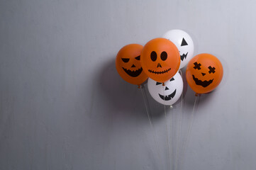 Orange and white balloons for Halloween party on gray background. Space for text