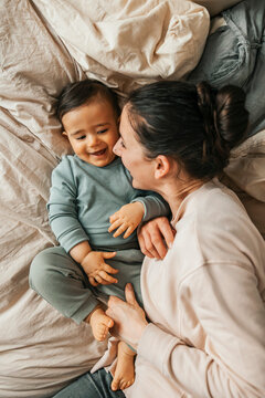 Directly above shot of mother spending quality time with son on bed at home