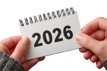 Hands holding a small notepad calendar with the year 2026 displayed