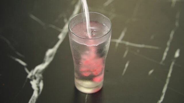 Close-up of collagen drink being poured into glass on table. Dietary supplements and collagen for body nourishment. Collagen water concept food nutrition, wellness health, anti aging treatment 
