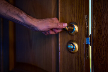 A hand is positioned on the door knob, fully prepared to open the entrance with ease
