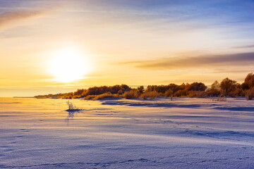 Scenic view of sunset and snow field. Field covered with a snow in cold winter season.