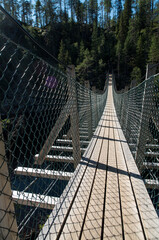 Fototapeta premium Lower angle of the suspension bridge over canyon in the Julma Ölkky National Park Finland