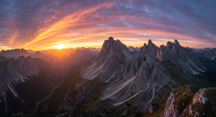 Stunning sunset over jagged mountain peaks with vibrant colors and dramatic sky views