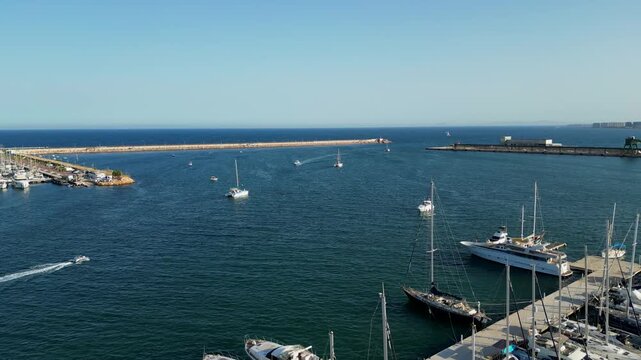 yacht - ship leaving the doc port with group of jet skis behind on the waves in blue sea - drone footage 2in1