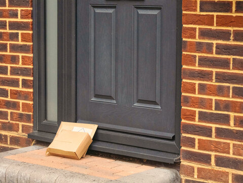Delivered cardboard packages being left outside at front door