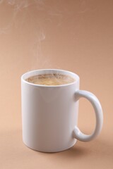 Aromatic coffee in cup on beige background. Mockup for design
