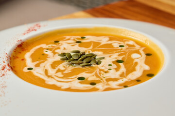 Indulge in a bowl of Delicious Creamy Pumpkin Soup beautifully topped with Garnish