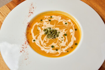 Indulge in a Rich and Velvety Pumpkin Soup with Cream and Seeds for a delightful experience