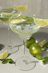 Martini cocktails with lime and mint on grey table, closeup