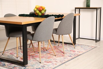 Bowl of fruits on wooden table in dining room. Interior design