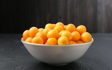 Ripe yellow cherry plums on black table, closeup