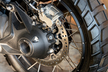 Close-up view of a motorcycle wheel and brake system showcasing intricate details and high-quality design during the morning light