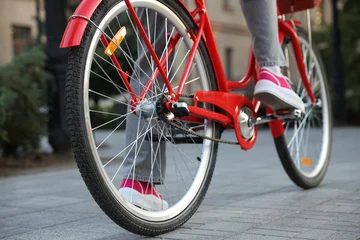 Fototapete Fahrrad Teenage girl riding bicycle on city street, closeup  © New Africa