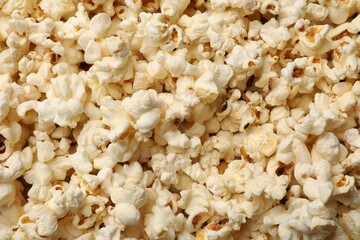 Fresh tasty popcorn as background, closeup view