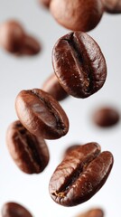 Fototapeta premium Floating coffee beans close up studio shot on white background for food and drink concepts and advertising material