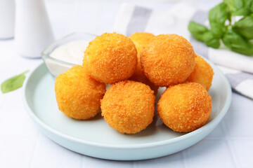 Delicious fried croquette balls on light tiled table, closeup