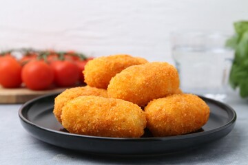 Delicious fried croquettes on gray table, closeup