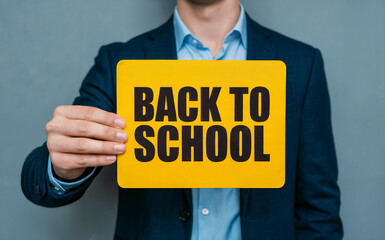 Person holding "Back to School" sign, symbolizing the academic season, education, and new learning opportunities.
