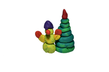 A figurine made of plasticine. The snowman stands next to the Christmas tree.