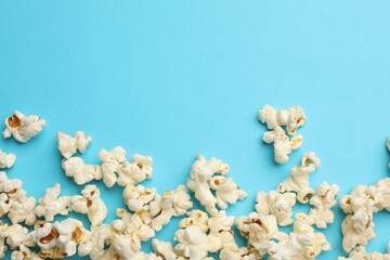 Tasty popcorn on light blue background, flat lay. Space for text
