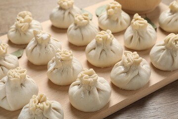 Uncooked khinkalis (dumplings) on wooden table, closeup