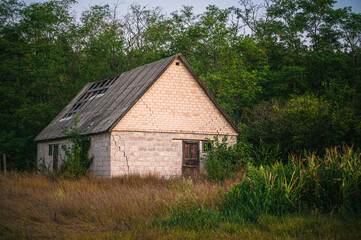 Fototapeta premium Dilapidated village house with decorative wooden gable