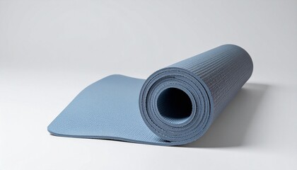 Partially unrolled blue yoga mat with textured surface on neutral background