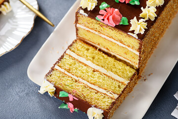Sliced ​​layered cake with buttercream on white plate.