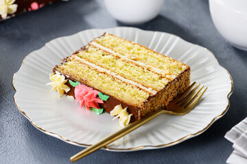 Piece of  layered cake  with buttercream on white plate.