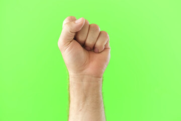 Naklejka premium Male Hand Making Rise Up Sign Symbol. Chroma Key Green Screen Background. Gesture Movement. Body Language. 4K Footage. Close Up. Raised Hand. Clenched Closed Fist. Raised Up. Human Equal Rights. Vote