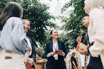 Low angle view of happy female business professional enjoying networking with experts at convention center