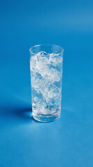 Glass with crushed ice and condensation on blue background refreshing and clean minimal drink vibe

