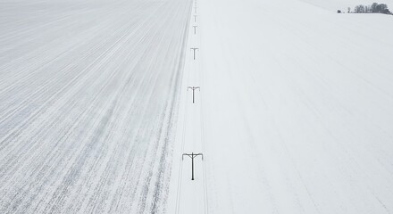 Aerial view of a snow-covered landscape with power lines.