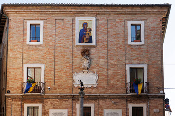 Facade of an old Renaissance building with Madonna icon in the historic center of Urbino, Marche, Italy, Europe