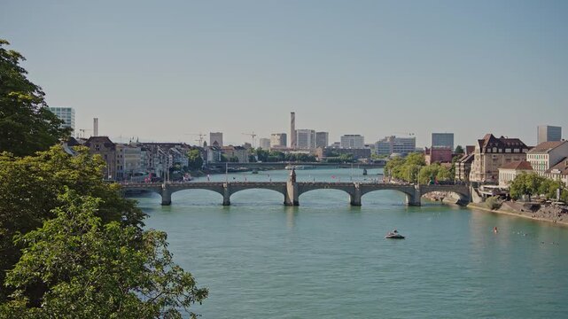 Wide view of the historic Mittlere Br&uuml;cke bridge over the Rhine River in Basel, Switzerland, filmed on July 25, 2025.