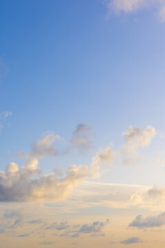 Vertical photo of pastel blue and golden sunset beautiful cloudscape.