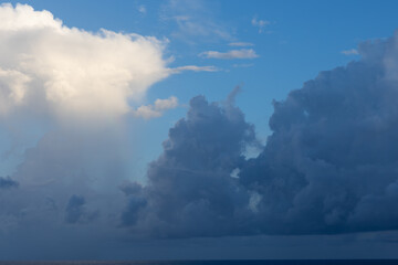Cloudscape photo of tall high altitude cumulonimbus clouds dark blue storm clouds light fluffy airy clouds.