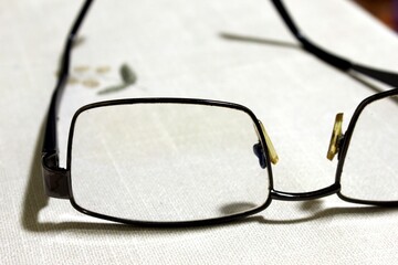 eye glasses. glasses with lenses for improving vision are lying on a white table surface