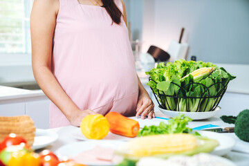 Pregnant Woman Cooking Vegetables, Fruits, Corn, and Bread in Kitchen for Healthy Diet, Nutrition, Wellness, and Balanced Organic Lifestyle
