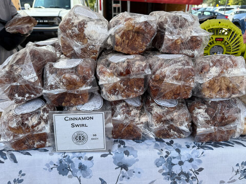 Enjoying Fresh Baked Goods at Holland Michigan Farmers Market With Cinnamon Swirl Treats - Powered by Adobe