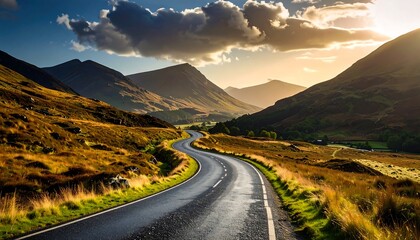 A winding road through a valley of golden hills under a vibrant sunset sky.