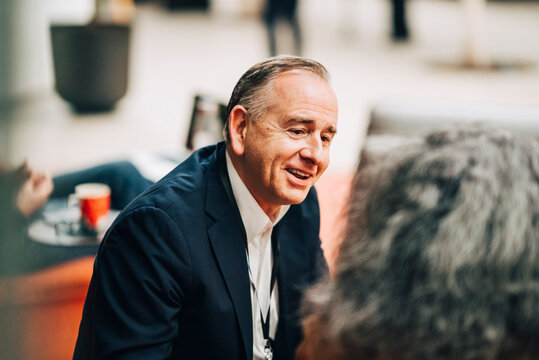 High angle view of male business expert communicating with colleague at networking event in convention center