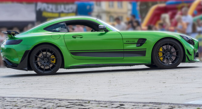 Polska, Ostrowiec Świętokrzyski, 20 lipca 2025, 14:08. Zielony MERCEDES AMG GT - R V8 BI TURBO na brukowanym placu. Samoch&oacute;d sportowy wyr&oacute;żnia się czarnymi felgami aluminiowymi, ż&oacute;łtymi hamulcami