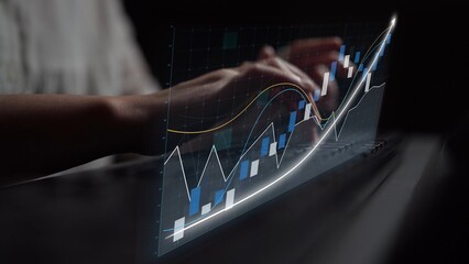 A close-up view of hands working on a laptop with a transparent overlay of charts and graphs, representing modern data analysis and financial trends in a dark environment. Copula