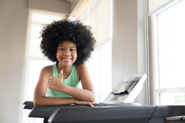 Happy smiling teenage girl in gym. African American teenage girl   workout in sport club