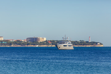 Obraz premium Large white yacht is in Gelendzhik Bay. In background is Gelendzhik lighthouse.