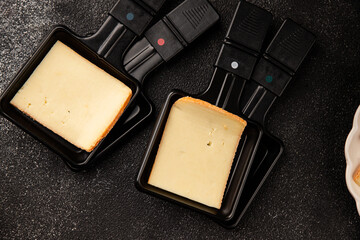 Raclette cheese portion slicing natural product tasty snack fresh delicious gourmet food background on the table rustic top view copy space